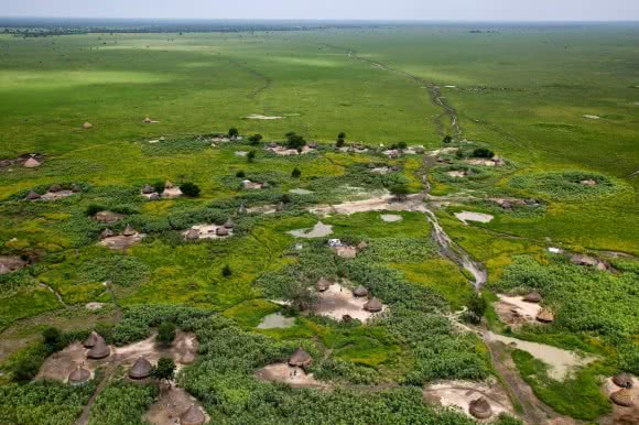 South Sudan from above. There are just a few paved roads throughout the country and other paths, such as the one below get flooded during the rainy season and become impassable. Even though the landscape looks lush and green, many people could not plant in time for the rainy season. 70,000 people displaced by the conflict have found shelter in Uror, many walked for several days of a week to reach Uror. Many came without any possessions, they have very little to eat and they survive with leaves and fruit. Photo Josh Estey/CARE