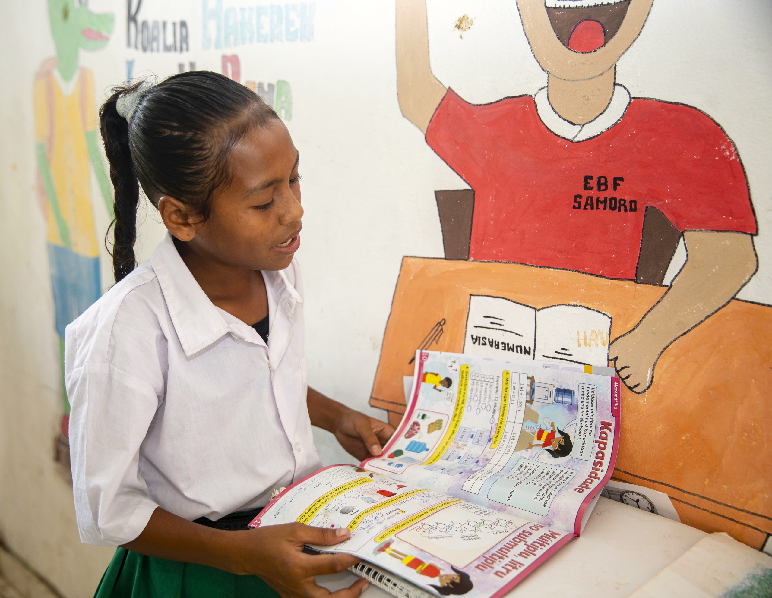 USE THIS EDITED VERSION_Ana Rosa reading Lafaek magazine in rural Manatuto_Jaime da Costa