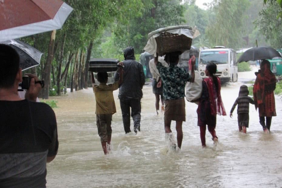People wade to safety after severe flash floods hit south-east Bangladesh.