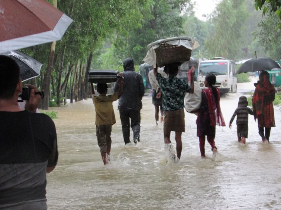 People wade to safety after severe flash floods hit south-east Bangladesh.