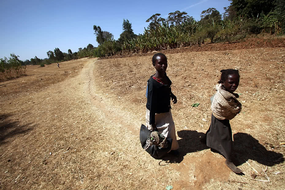 An Ethiopia woman and child walk across a parched landscape in Ethiopia.