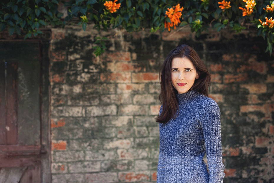 Lauren Shuttleworth posing against brick wall.