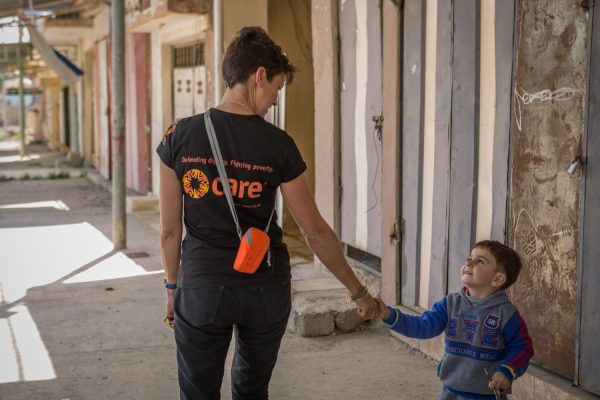 Jacqui Symonds, CARE’s Head of Programs in Kurdistan Region of Iraq, greets a little boy who has recently returned to his home on the outskirts of Mosul in Iraq. Image © Emily Kinskey/CARE