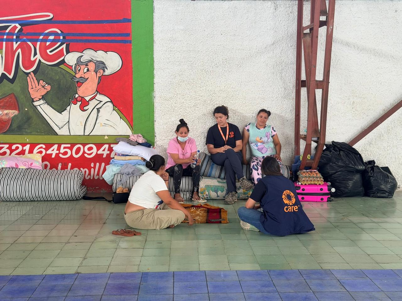 CARE workers listen to displaced mothers in a temporary shelter, assessing immediate needs for shelter, food, and emotional support. Photo © CARE/Lorena Bejarano