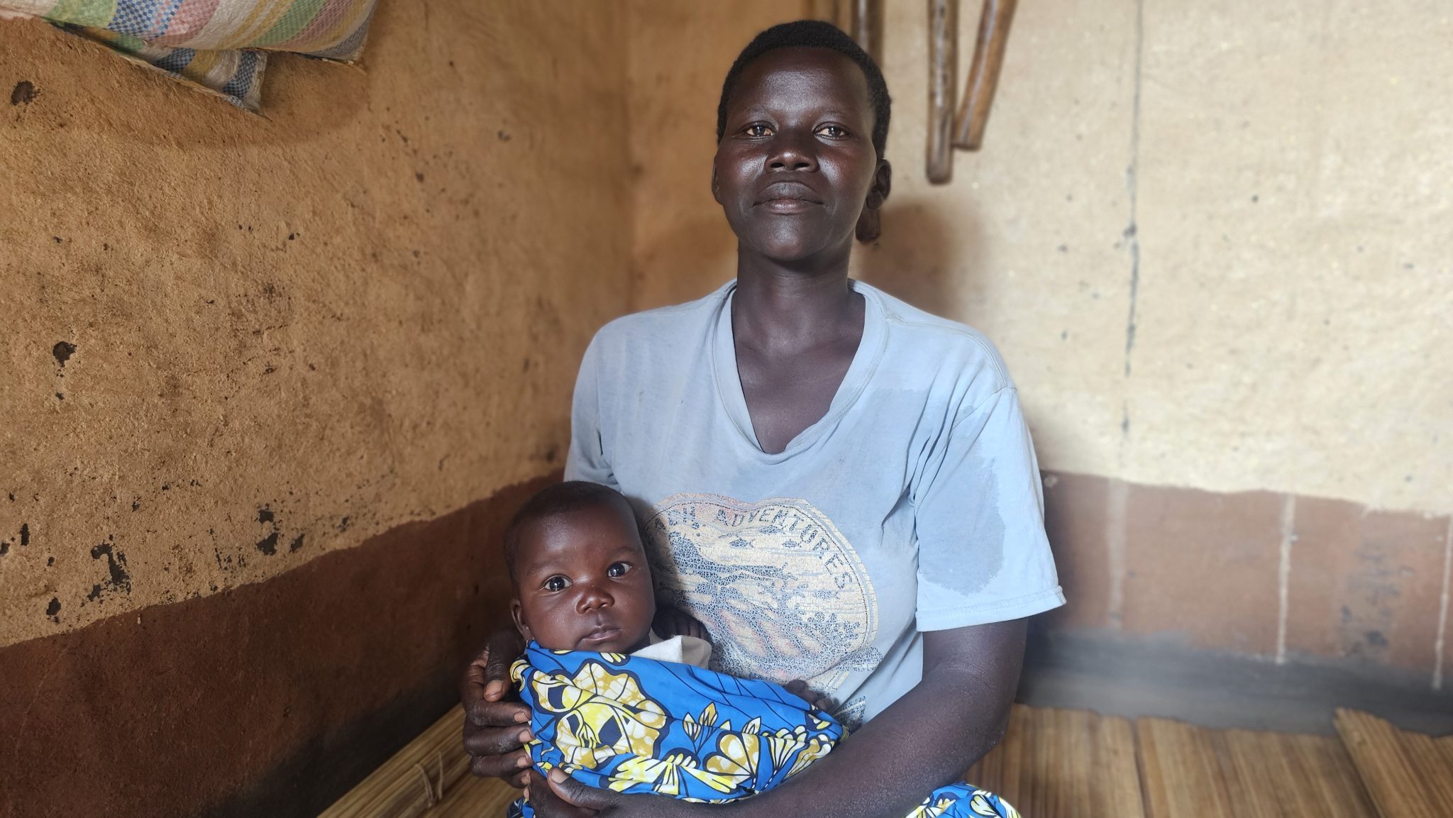 Chantal holding Dorcas on the bamboo mat where she gave birth. Photo © CARE/Sarah Easter