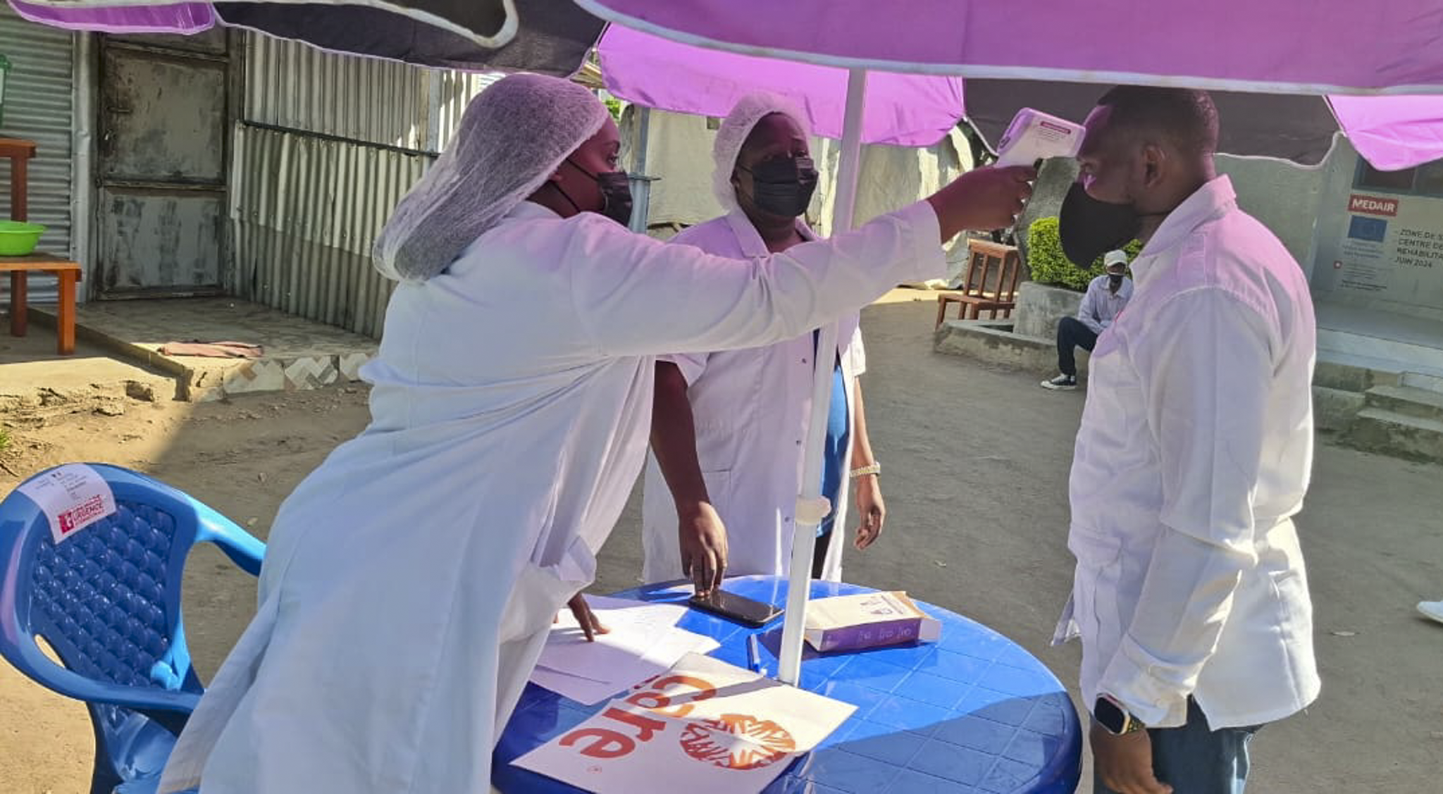 Health workers screen visitors at the entrance of a CARE-supported facility in eastern DRC. Rapid detection and infection prevention are critical to containing the Bundibugyo strain of Ebola, for which no approved vaccine or treatment currently exists.